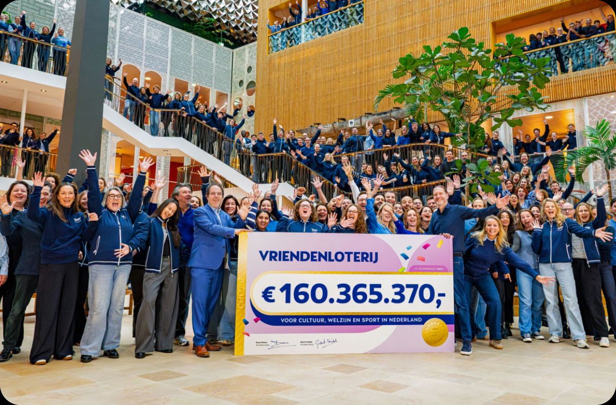 VriendenLoterij-collega's op het binnenplein juichen en houden een grote cheque vast met een bedrag van €160.365.370.